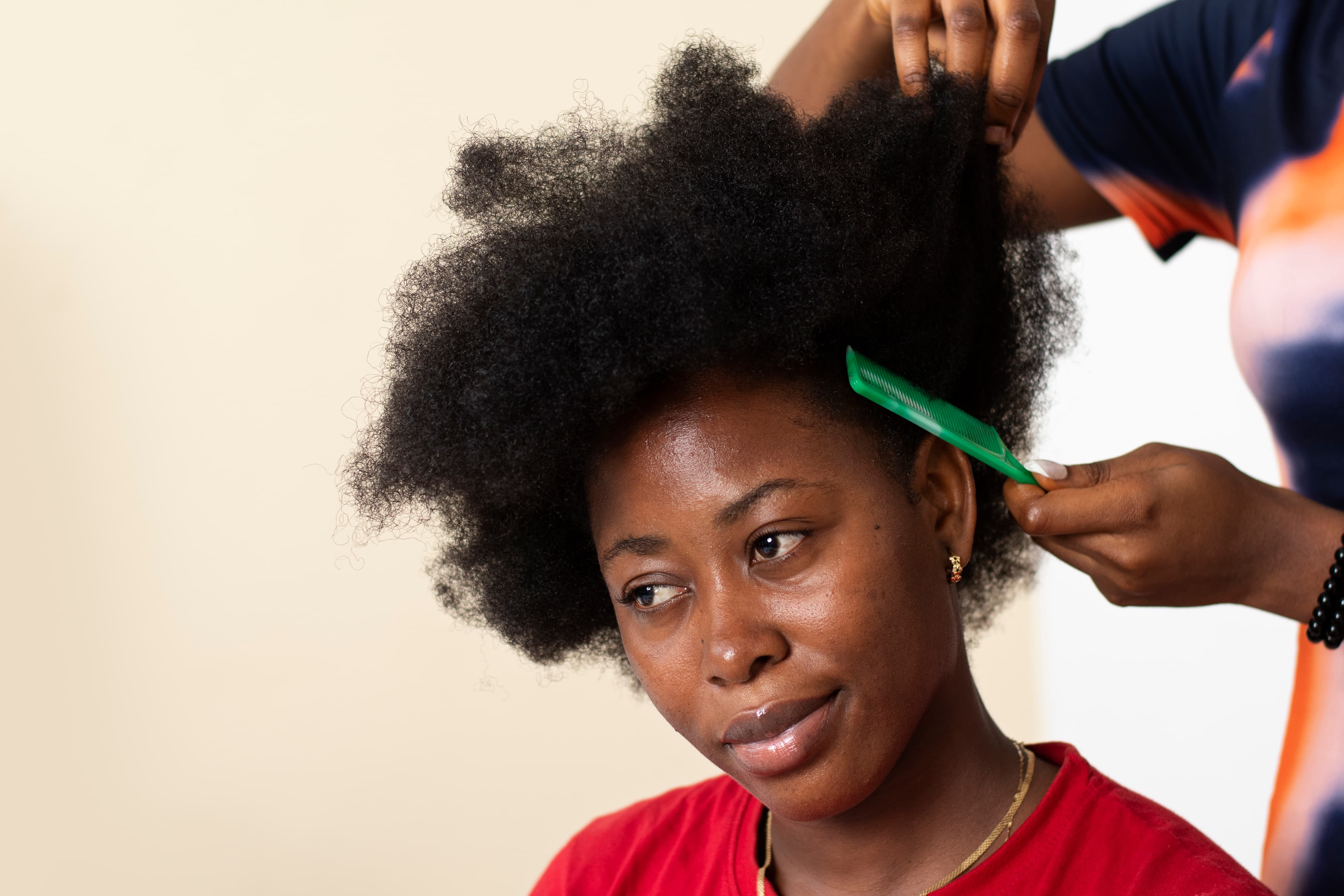 Coiffeuse qui s'occupe des cheveux afro d'une cliente
